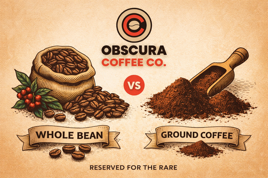 Fresh roasted whole bean coffee and a manual grinder on a rustic wooden table by Obscura Coffee Co.